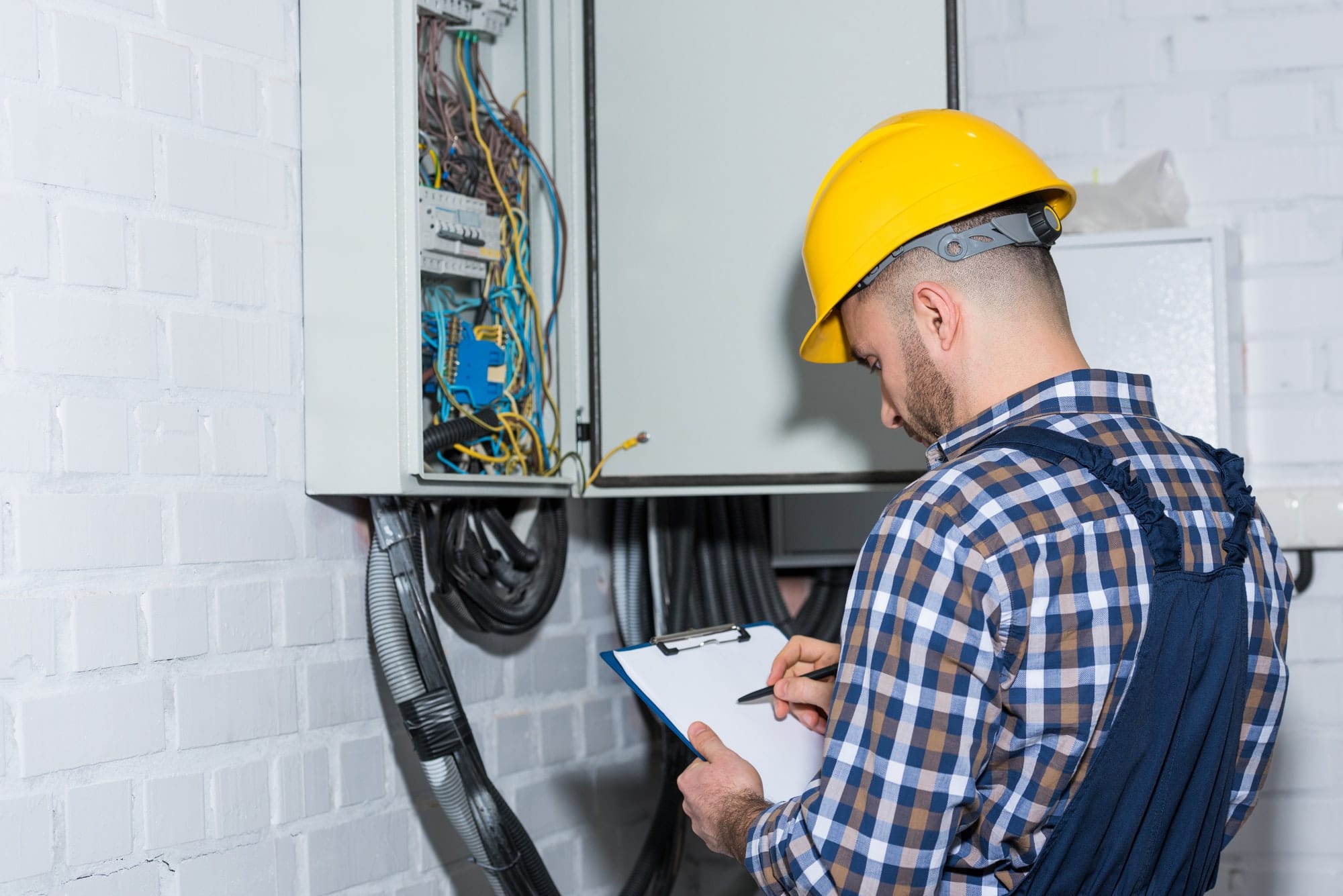 professional electrician inspecting wires in electrical